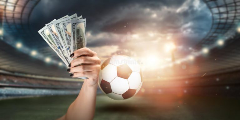close-up-man-s-hand-holding-us-dollars-against-background-stadium-concept-sports-betting-making-profit-gambling-208405993